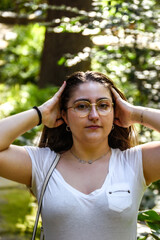 Young woman with her hands on her head while smiling at the camera