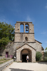 Femme touriste entrant dans la vielle église de Naves village de caractère près des Vans dans l'Ardèche du sud