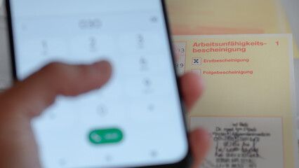 Telefonische Verlängerung der Krankmeldung: Hand wählt Nummer auf Smartphone und Arbeitsunfähigkeitsbescheinigung - obrazy, fototapety, plakaty