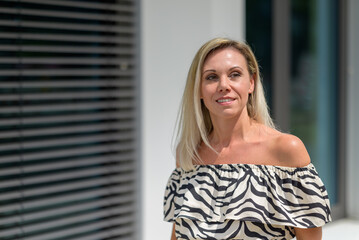 Fototapeta premium Stylish blond woman giving the camera a friendly smile