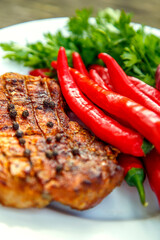 Meat steak cooked on the barbecue. Grilled fresh meat steak with spices and red pepper. Ready steak on the table with tomatoes and peppers. The concept of food, restaurants, traditional cuisine.