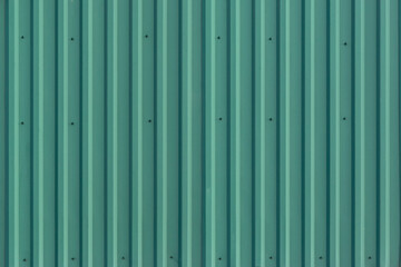 Green profiled sheeting close up. wall with embossed background texture. corrugated board.