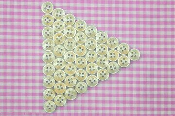 Plastic shiny buttons for clothes on a fabric background. Fashion and clothing. Factory industry