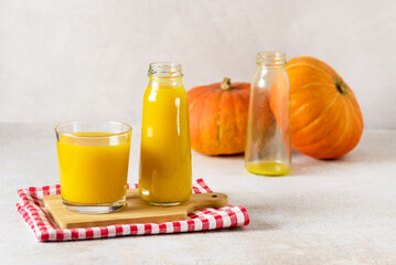 Freshly Squeezed Pumpkin Juice in Glass Bottle with Yellow Juice on Wooden Tray Napkin Vegetarian Breakfast Healthy Food Copy Space