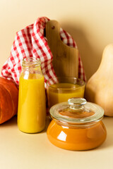 Pumpkin Pudding in Glass Bowl and Pumpkin Juice on Napkin Raw Pumpkin Harvest Autumn Yellow Background Vertical