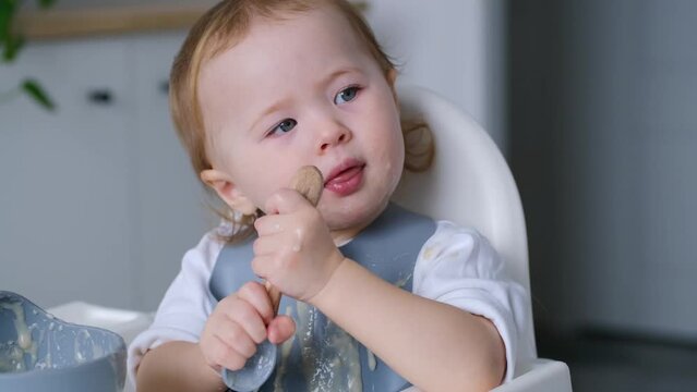 4K video Baby sitting in high chair at home drinking water. Toddler at mealtime. Baby-led weaning.