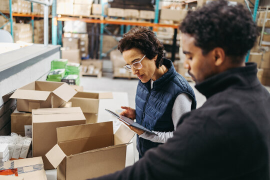 Logistics workers fulfilling orders using a digital warehouse management system