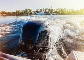 View of the stern of a motorboat dinghy with a outboard engine running very fast on the river