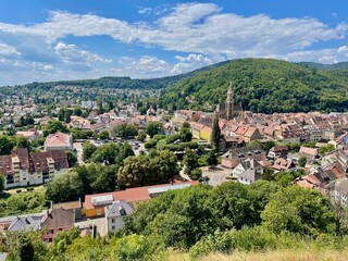 Fototapeta na wymiar Aerial view over the rooftops of the city of Thann in Alsace on a sunny summer day