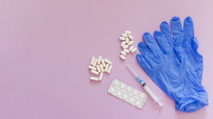Blue gloves with pills and syringe