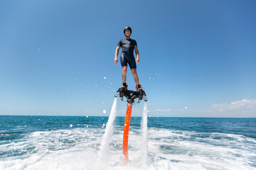 Water extreme sport. The guy is flying at the aquatic flyboard. A lot of water pressure