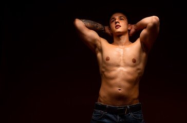 Strong athletic man showing six pack abs isolated on black studio background