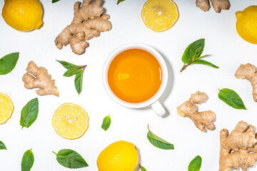 Healthy organic vegan immunity booster, herbal drink. Antioxidant anti-inflammatory ginger lemon tea with ingredient - fresh ginger, lemon, mint, white background flatlay top view copy space