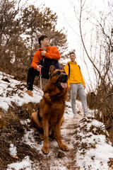 Taking a break with the dog in the forest while smiling and enjoying their time