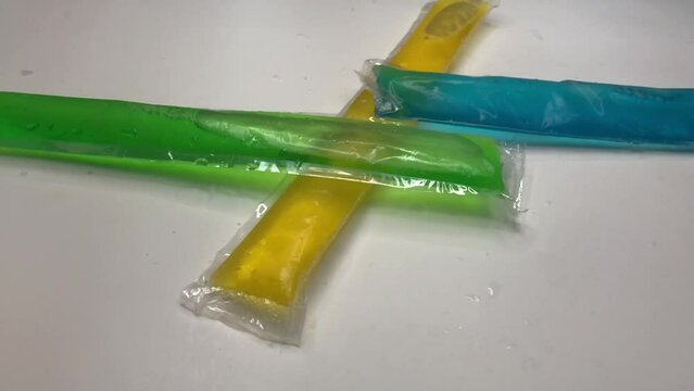 Multicolored Popsicles Fall Into Frame