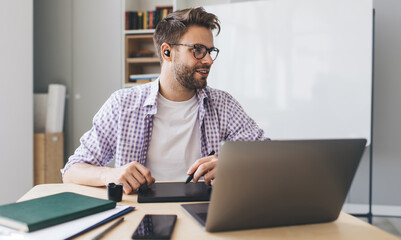 Millennial businessman working at desk in office