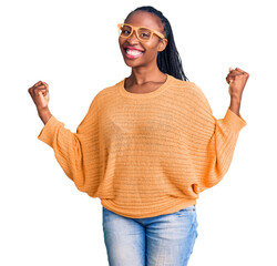 Young african american woman wearing casual clothes and glasses screaming proud, celebrating victory and success very excited with raised arms