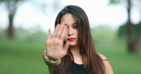 Obraz premium Young woman gesturing to stop with hand and finger waving NO