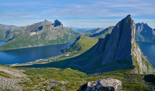 View from the mount Hesten on iconic mountain Segla in a summer sunny day. Mountain ranges at the background. Fjordgard, Senja island, Norway. Summer vacation in Lofoten   