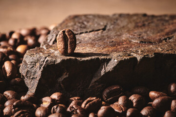 Roasted coffee beans on stone pedestal brown background