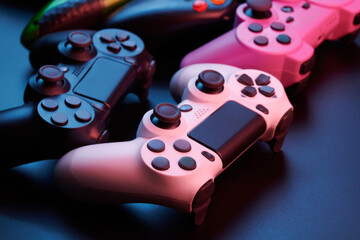 Many different video game controllers, multicolored joysticks for game console isolated on black background. Gamer controlling devices close-up © amixstudio