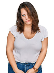Young plus size woman wearing casual white t shirt looking sleepy and tired, exhausted for fatigue...