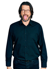 Middle age caucasian man wearing casual clothes and glasses sticking tongue out happy with funny expression. emotion concept.