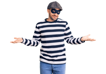 Young handsome man wearing burglar mask smiling showing both hands open palms, presenting and advertising comparison and balance