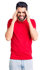 Fototapeta premium Young handsome man with beard wearing casual t-shirt with hand on head for pain in head because stress. suffering migraine.