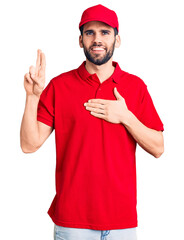 Young handsome man with beard wearing delivery uniform smiling swearing with hand on chest and...