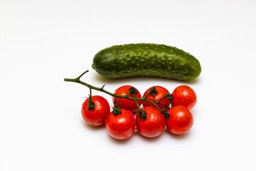 fresh cherry tomatoes and green cucumber lie in a basket