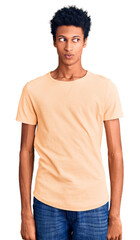 Fototapeta premium Young african american man wearing casual clothes smiling looking to the side and staring away thinking.