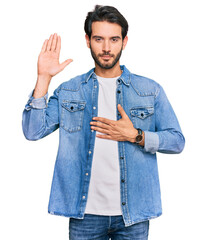 Young hispanic man wearing casual clothes swearing with hand on chest and open palm, making a...