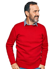 Fototapeta premium Middle age hispanic man wearing casual clothes looking away to side with smile on face, natural expression. laughing confident.
