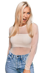 Fototapeta premium Young blonde woman wearing casual clothes winking looking at the camera with sexy expression, cheerful and happy face.