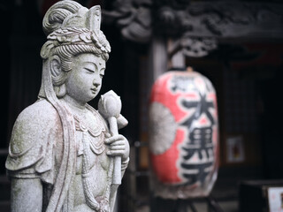statue of buddha holding a rose in a quiet temple of tokyo