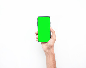 Mano de un hombre caucasico sosteniendo su smarphone en un fondo blanco y la pantalla del telefono inteligente esta en color verde para aplicar montajes de green screen 