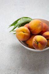 Fresh peaches fruits in white bowl food copy space summer concept