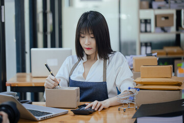 Businesswoman using laptop computer online chat with packaging box, Business online influencer on social media concept, Online Selling, Online Shopping to market.