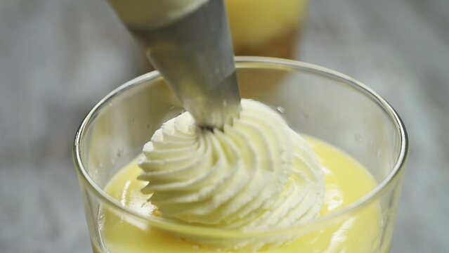 The chef decorates the dessert with cream made of whipped cream and powdered sugar.
