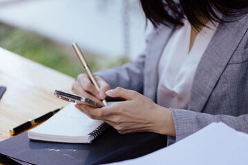 Close up of businesswoman hands using smart phone at workplace in office.