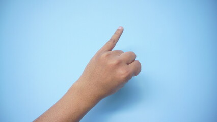 American sign language. Female hand showing letter I isolated on blue background.
