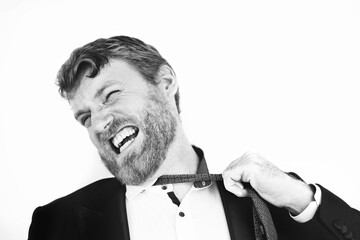 A businessman in a suit pulling his tie and flinching in emaitional pain and stress