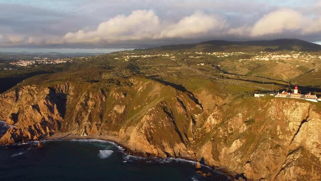 Wild impregnable rocky coastline of Portugal, Lisbon area. Aerial view at scenic huge cliffs with waving Atlantic ocean in the foot, breathtaking view of westernmost point of Europe - Cape Roca