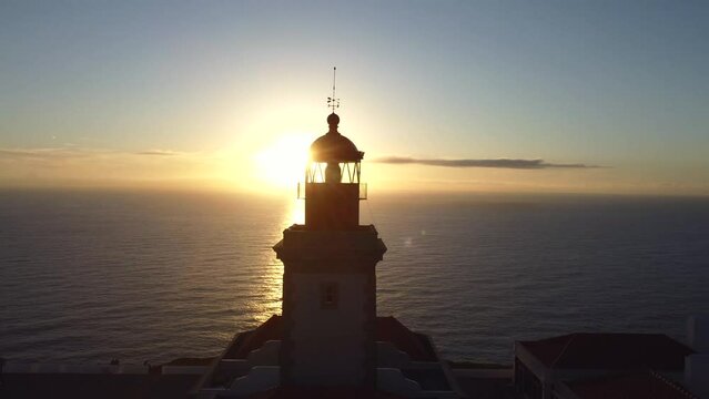 Aerial view at beacon light. Drone flying near lighthouse in the amazing warm sunset light, ocean view, Cape Roca, Portugal