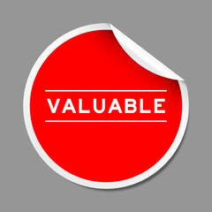 Red color peel sticker label with word valuable on gray background