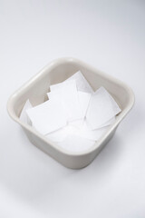 white pieces of napkins in a square plate on a white table