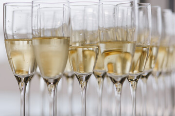 Bartender pouring champagne or wine into wine glasses on the table at the outdoors solemn wedding ceremony