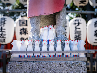 collection of statues of cute inari foxes at a japanese shinto shrine in tokyo, Japan 