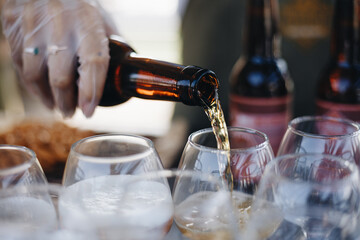 Mid section of bartender pouring beer in a glass at bar counter